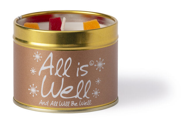 Lily-Flame All is Well scented tin candle with a decorative label and a lit wick, emitting warm, inviting light.