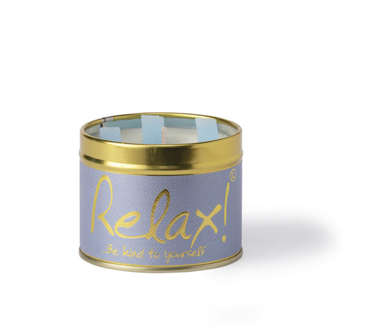 Lily-Flame Relax scented tin candle with a decorative label and a lit wick, emitting a calming glow.