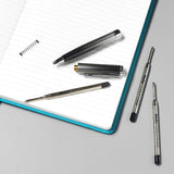 Two Oxford Helix Oxford ballpoint pen refills with black ink, showing the pen tips and packaging.