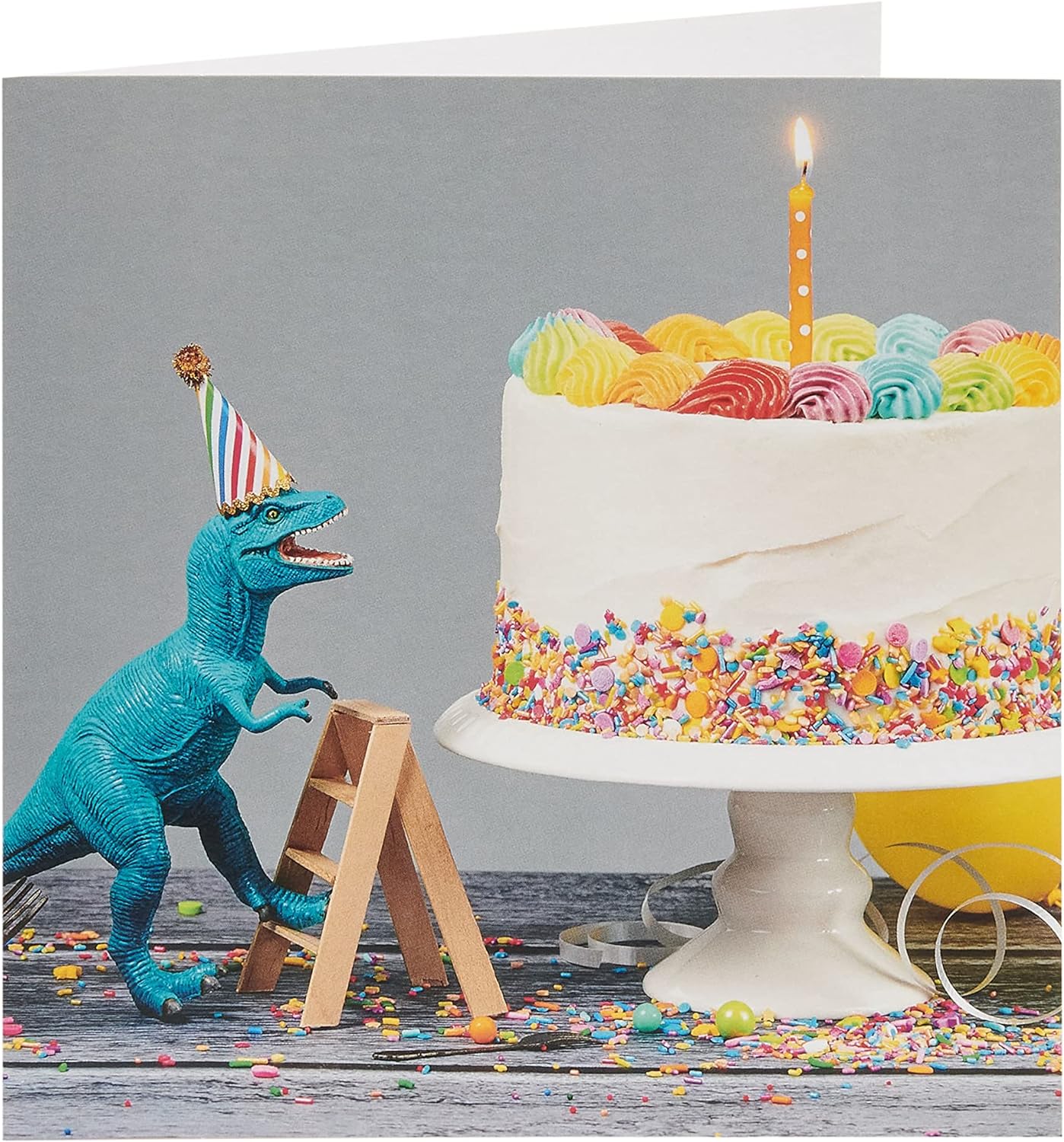 Birthday greeting card for him or a friend featuring a colorful cake and dinosaur design from UK Greetings.