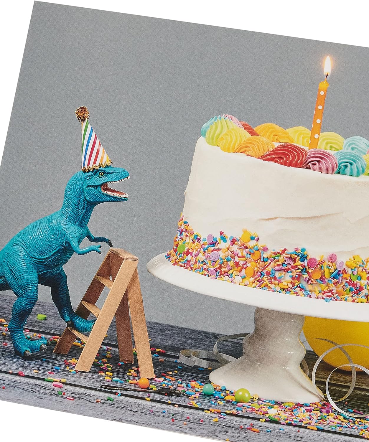 Greeting card for him or friend featuring a cake and dinosaur design, by UK Greetings, with colorful birthday illustrations.