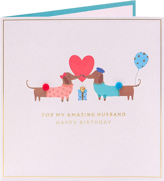 Cute sausage dog husband birthday greeting card from UK Greetings featuring a charming illustration of a sausage dog.