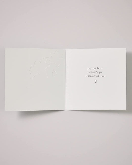 Elegant lilies sympathy greeting card by UK Greetings featuring floral design, suitable for expressing condolences.