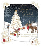 Grandma and Grandad Christmas greeting card featuring a festive holiday scene with Christmas trees and winter decorations, by UK Greetings.