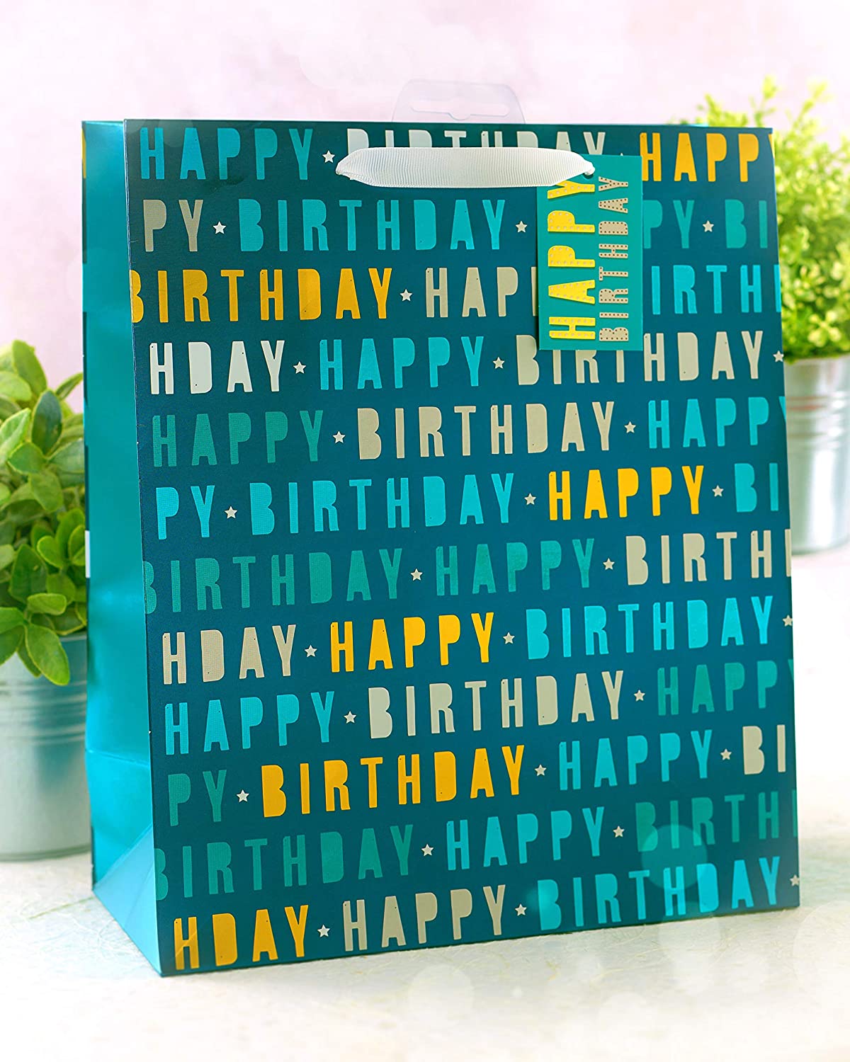 Blue large Happy Birthday gift bag with greeting card from UK Greetings, featuring festive designs and space for gifts.