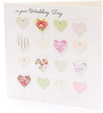 Luxury wedding greeting card by UK Greetings featuring 3D hearts and silver foil accents.