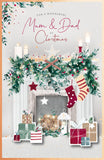 UK Greetings Mum and Dad fireplace Christmas greeting card with festive design for holiday wishes.