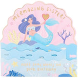 Colorful pop-up mermaid sister birthday greeting card from UK Greetings featuring vibrant ocean-themed design and cheerful message.