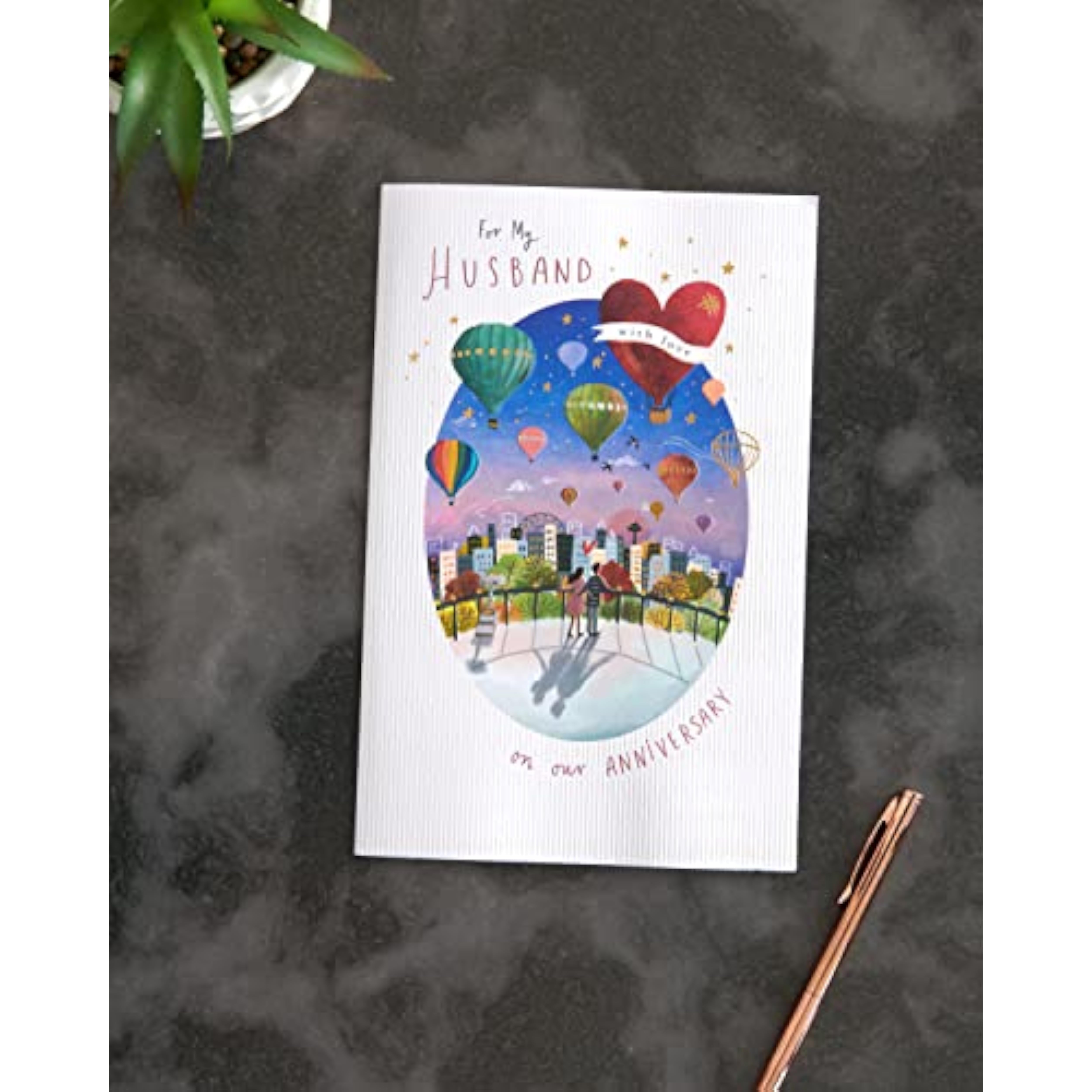 Colorful hot air balloon anniversary greeting card for husband by UKG, shown with envelope. Bright, cheerful design.