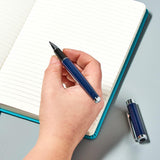 Helix Oxford Premium Rollerball Pen with blue ink, shown in plastic-free packaging, featuring a sleek design and smooth writing tip.