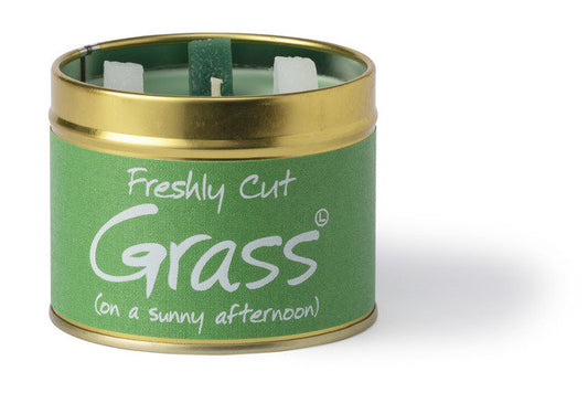 Lily-Flame Freshly Cut Grass scented tin candle with a green label, featuring a natural, relaxing outdoor grass scene.