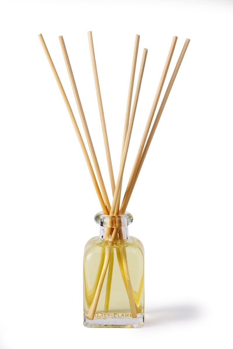 Lily-Flame reed diffuser refills with natural reed sticks for aromatic home fragrance, arranged in a clear container.