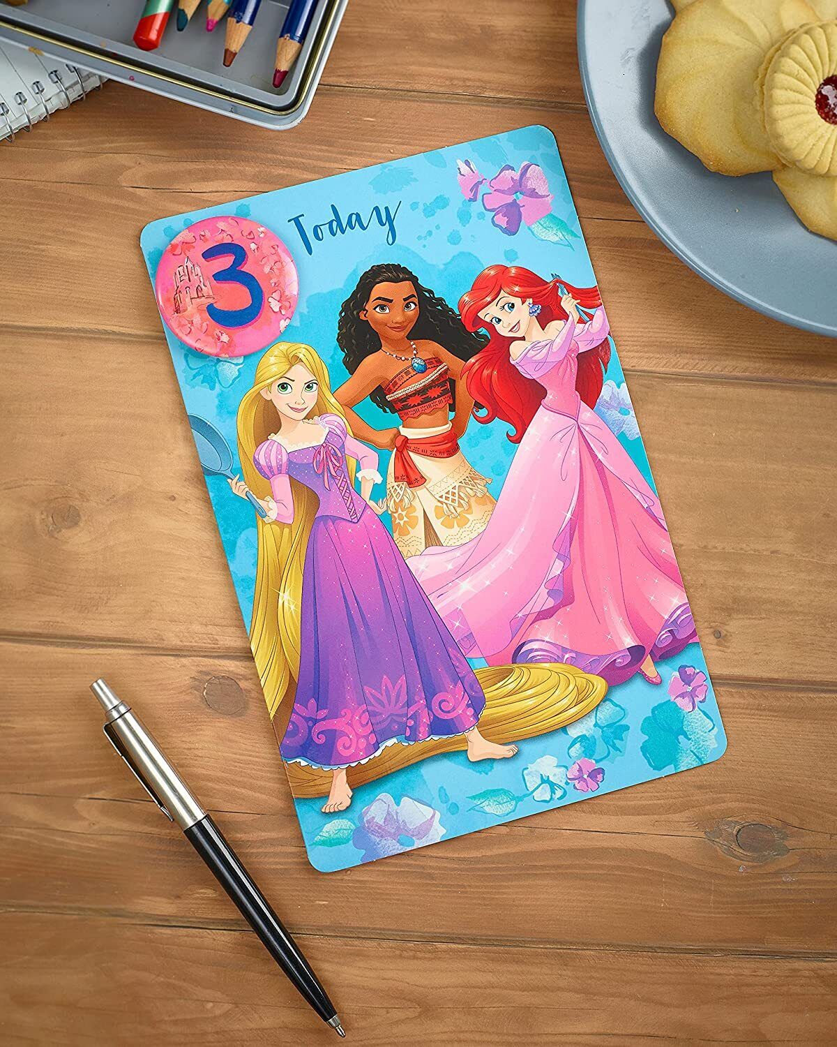Disney Princesses 3rd birthday greeting card with badge featuring colorful princess illustrations and festive design.