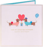 Cute sausage dog husband birthday greeting card from UK Greetings with colorful, playful design featuring a cartoon-style sausage dog.