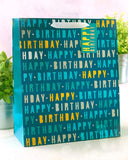 Large blue Happy Birthday gift bag with greeting card from UK Greetings, featuring festive birthday design.
