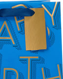 Medium blue UK Greetings gift bag with birthday lettering, featuring decorative design and handles for gift presentation.