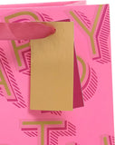 Medium pink gift bag with birthday lettering from UK Greetings, featuring decorative design for gift packaging.