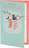 Festive Christmas greeting card by UK Greetings featuring colorful stockings and holiday-themed design for Nan and Grandad.
