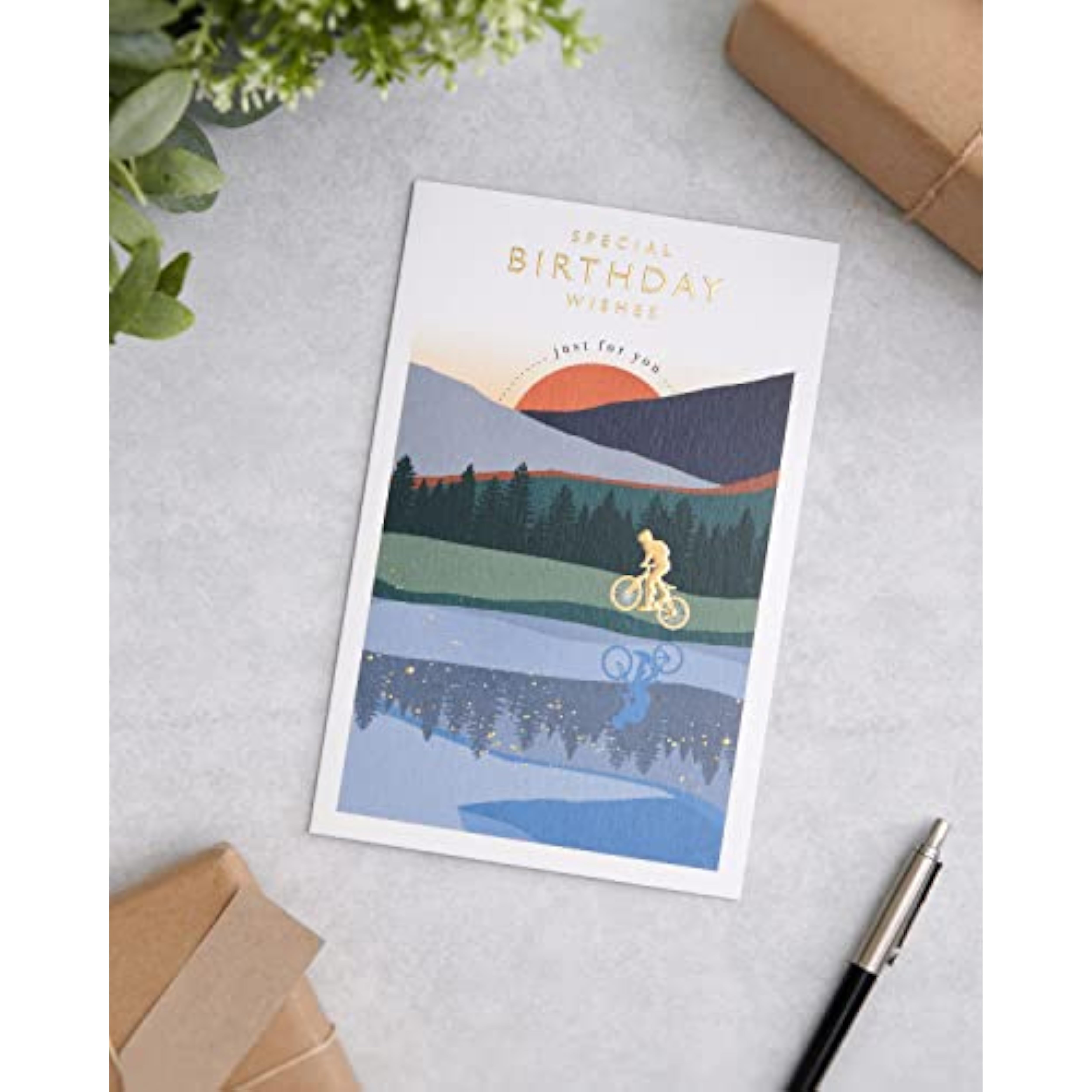 Birthday greeting card for him featuring a cyclist and sunset design with gold foil accents, by UKG.